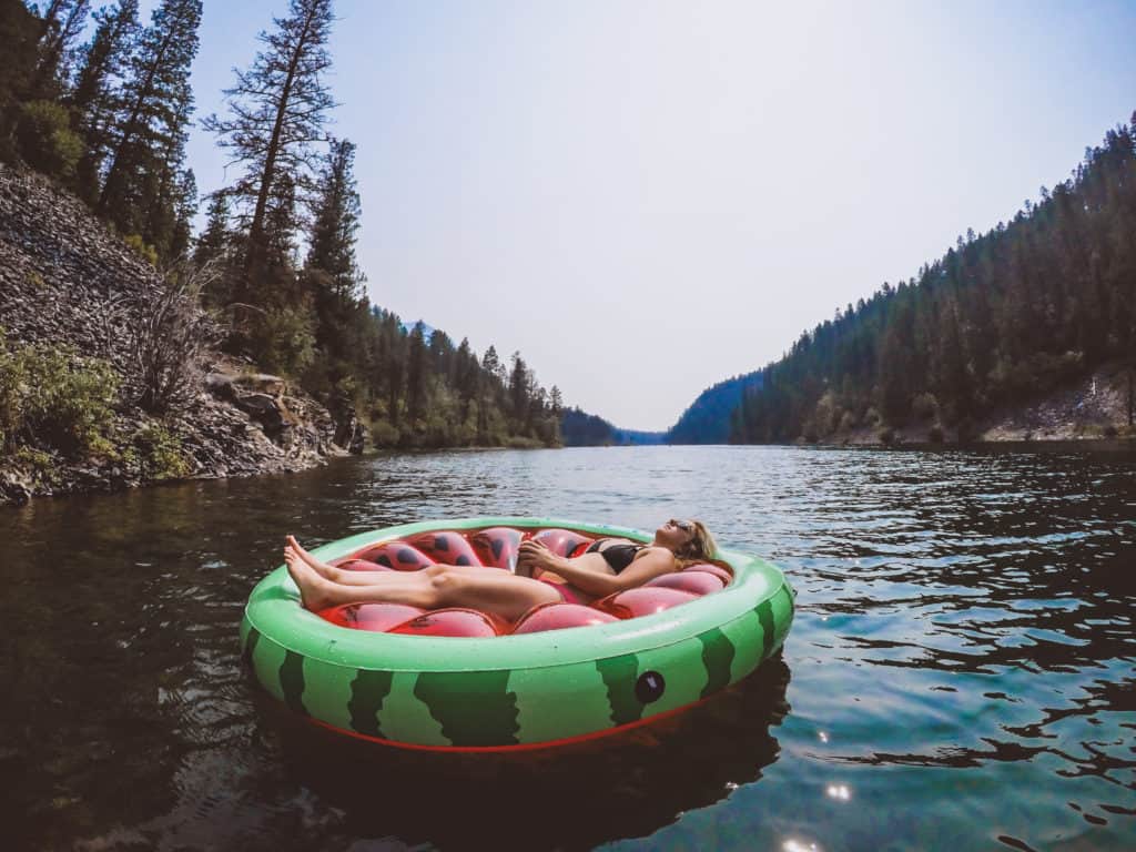 a girl floating on a watermelon floatie in a lake
