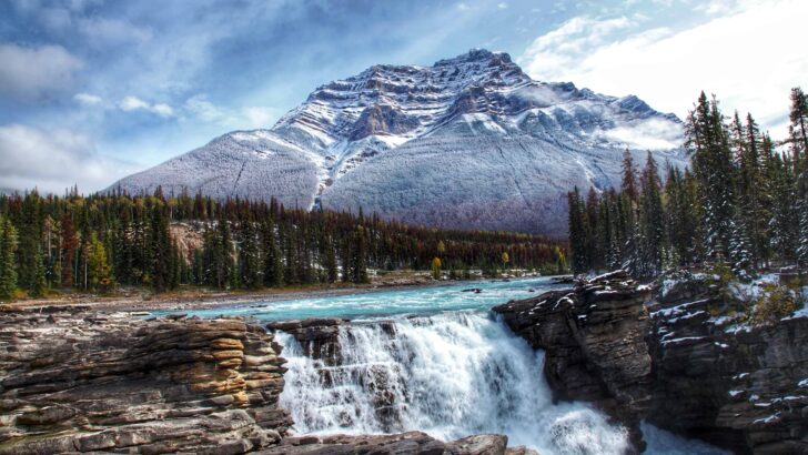 athabasca waterfall rushing down the cliff with mountain peak in background