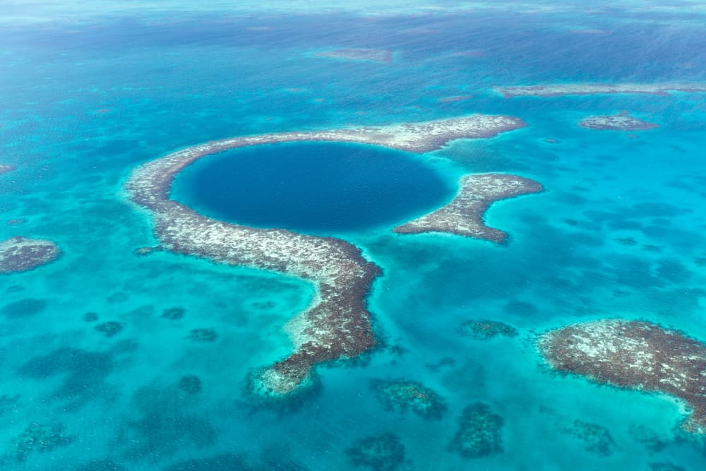 a massive dark blue hole in the middle of the turquoise ocean