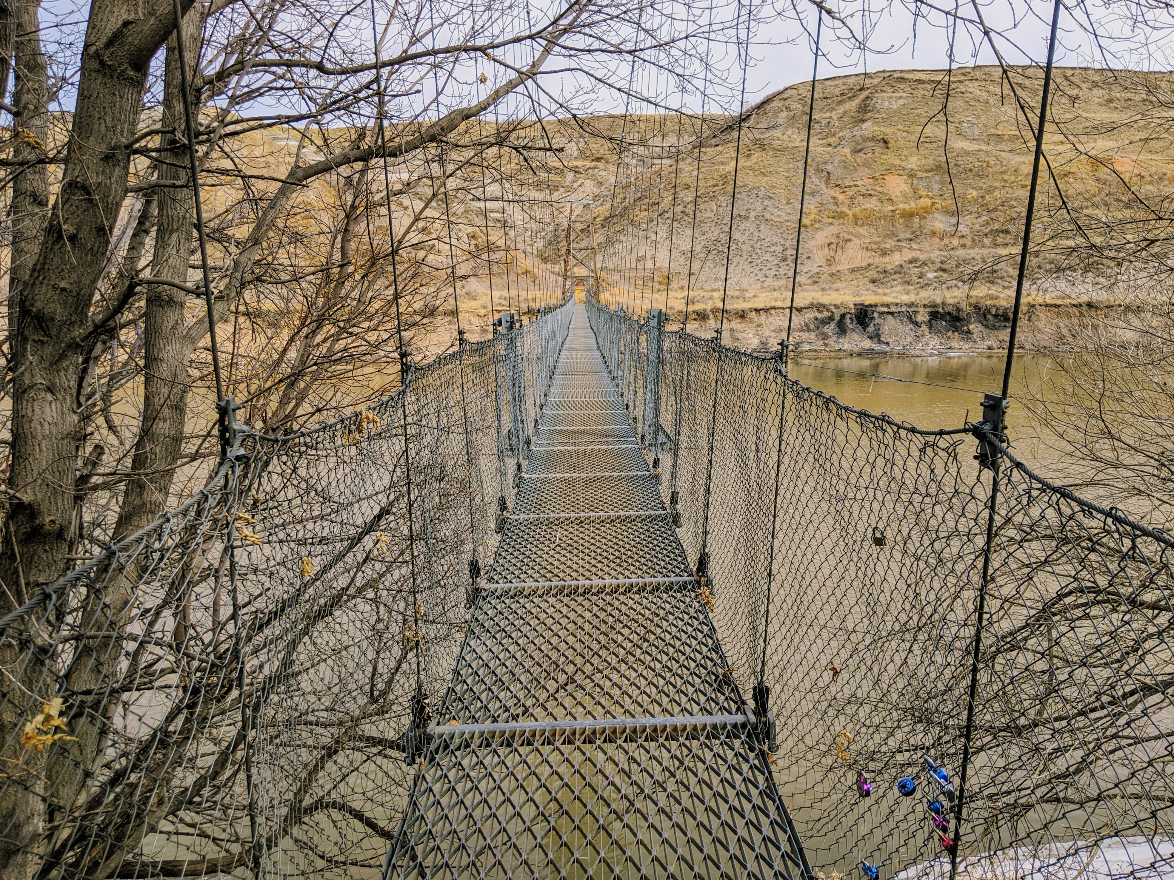 a suspension bridge across a river in the badlands