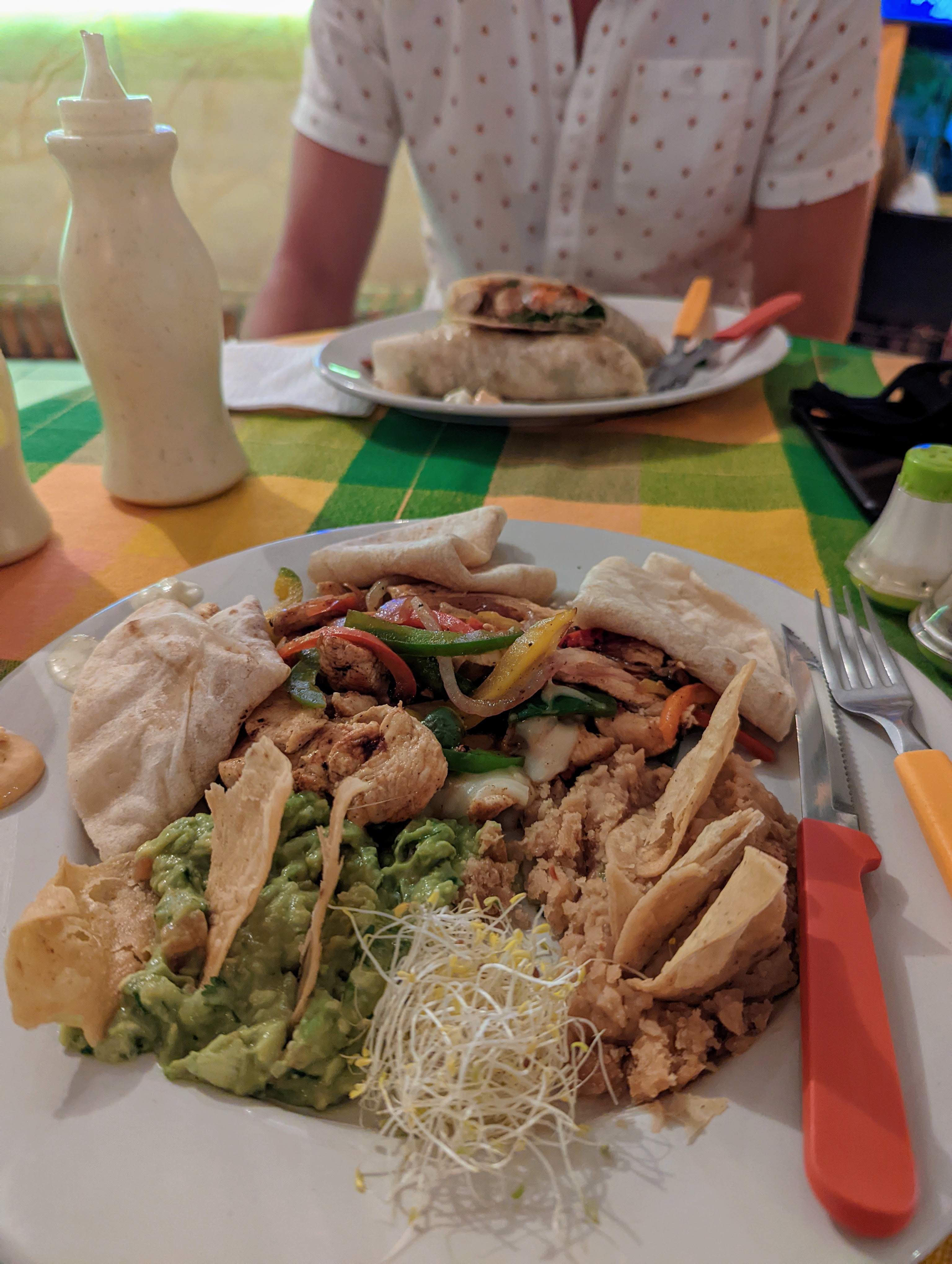 a large plate of peppers, chicken, guacamole and tortillas